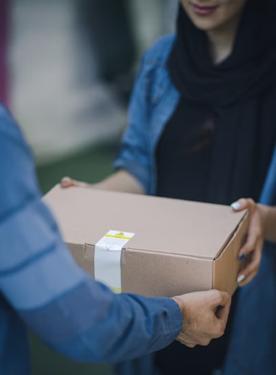 Personne qui livre une boite en carton